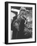 Shopper Looking at Tiny Figurine as She Holds Her Yorkshire Terrier in Arms at Saks Fifth Avenue-Yale Joel-Framed Photographic Print