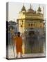 Shrine Guard in Orange Clothes Holding Lance Standing by Pool in Front of the Golden Temple-Eitan Simanor-Stretched Canvas