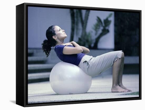 Side Profile of a Young Woman Exercising on a Fitness Ball-null-Framed Stretched Canvas
