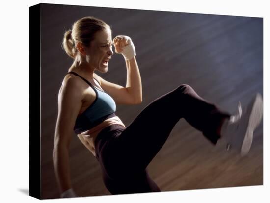 Side Profile of a Young Woman Kickboxing-null-Stretched Canvas