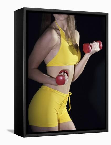 Side Profile of a Young Woman Lifting Dumbbells-null-Framed Stretched Canvas