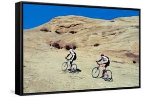 Side profile of two men mountain bilking on rocks, Slickrock Trail, Moab, Utah, USA-Richard Sisk-Framed Stretched Canvas