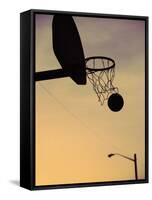 Silhouette of a Basketball Going Through a Basketball Net-null-Framed Stretched Canvas