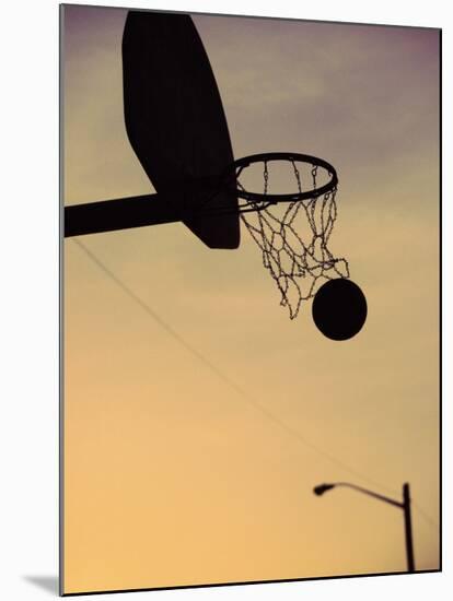 Silhouette of a Basketball Going Through a Basketball Net-null-Mounted Premium Photographic Print