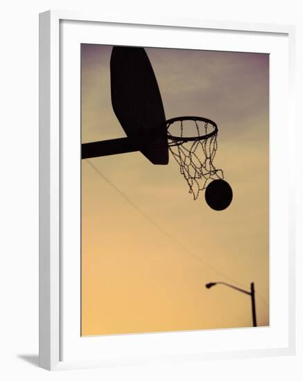 Silhouette of a Basketball Going Through a Basketball Net-null-Framed Photographic Print