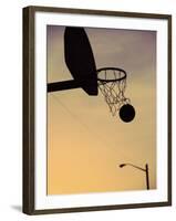 Silhouette of a Basketball Going Through a Basketball Net-null-Framed Photographic Print