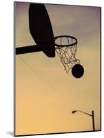 Silhouette of a Basketball Going Through a Basketball Net-null-Mounted Photographic Print