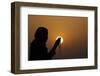 Silhouette of a Muslim woman holding prayer beads in her hands and praying at sunset-Godong-Framed Photographic Print