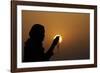 Silhouette of a Muslim woman holding prayer beads in her hands and praying at sunset-Godong-Framed Photographic Print