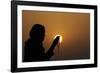 Silhouette of a Muslim woman holding prayer beads in her hands and praying at sunset-Godong-Framed Photographic Print