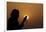 Silhouette of a Muslim woman holding prayer beads in her hands and praying at sunset-Godong-Framed Photographic Print