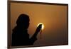 Silhouette of a Muslim woman holding prayer beads in her hands and praying at sunset-Godong-Framed Photographic Print