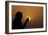 Silhouette of a Muslim woman holding prayer beads in her hands and praying at sunset-Godong-Framed Photographic Print