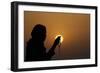 Silhouette of a Muslim woman holding prayer beads in her hands and praying at sunset-Godong-Framed Photographic Print