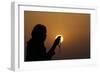 Silhouette of a Muslim woman holding prayer beads in her hands and praying at sunset-Godong-Framed Photographic Print