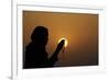 Silhouette of a Muslim woman holding prayer beads in her hands and praying at sunset-Godong-Framed Photographic Print