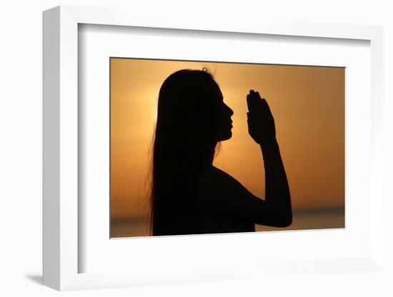 Silhouette of a woman standing by the sea at sunset doing yoga pose and meditation, Kep, Cambodia-Godong-Framed Photographic Print