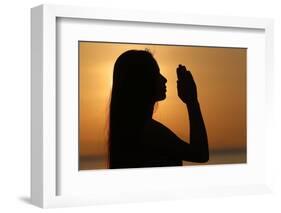 Silhouette of a woman standing by the sea at sunset doing yoga pose and meditation, Kep, Cambodia-Godong-Framed Photographic Print