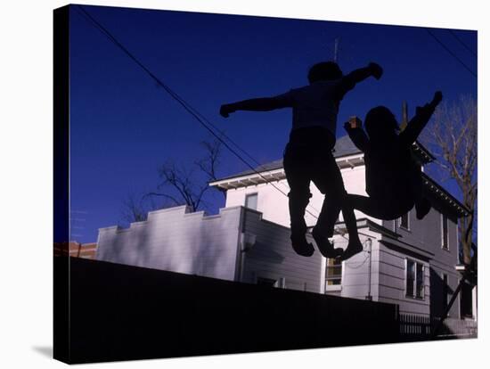 Silhouette of Children Bouncing on a Trampoline-Bill Eppridge-Stretched Canvas