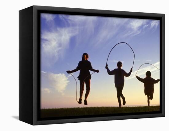 Silhouette of Children Jumping Rope Outdoors-Mitch Diamond-Framed Stretched Canvas