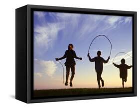 Silhouette of Children Jumping Rope Outdoors-Mitch Diamond-Framed Stretched Canvas