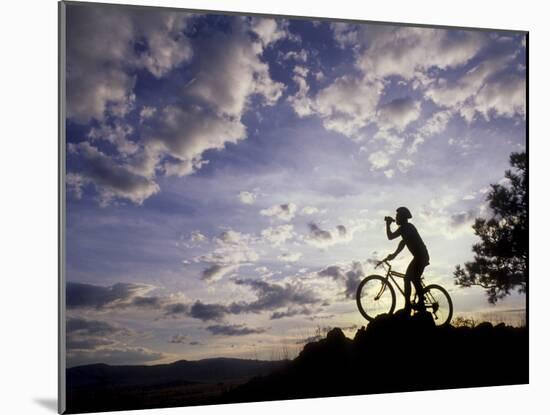 Silhouette of Mountain Biker Drinking at the Summit During Sunset-null-Mounted Photographic Print