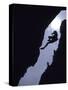 Silhouette of Rock Climber Hanging from Cliff Face-null-Stretched Canvas