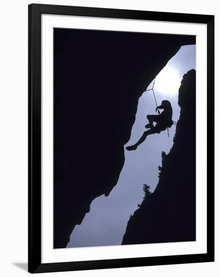 Silhouette of Rock Climber Hanging from Cliff Face-null-Framed Photographic Print