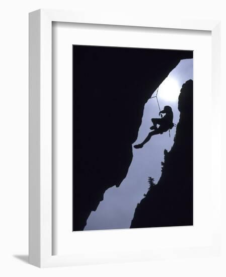 Silhouette of Rock Climber Hanging from Cliff Face-null-Framed Photographic Print