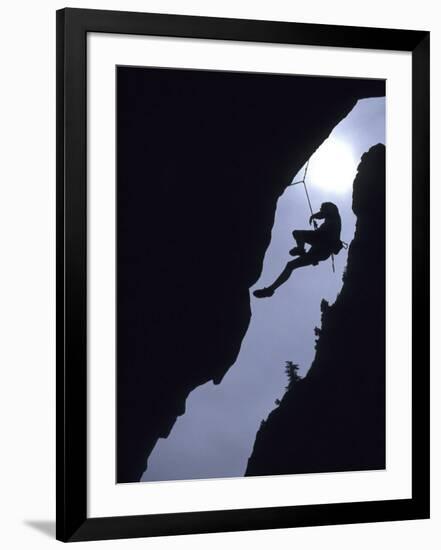 Silhouette of Rock Climber Hanging from Cliff Face-null-Framed Photographic Print