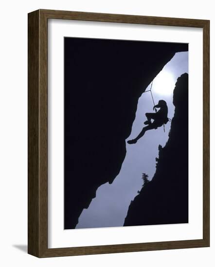 Silhouette of Rock Climber Hanging from Cliff Face-null-Framed Photographic Print