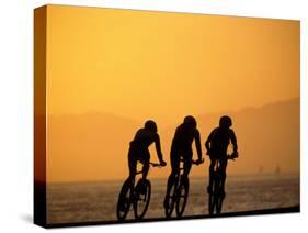 Silhouette of Three Men Riding on the Beach-Mitch Diamond-Stretched Canvas