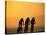 Silhouette of Three Men Riding on the Beach-Mitch Diamond-Stretched Canvas