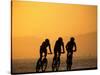 Silhouette of Three Men Riding on the Beach-Mitch Diamond-Stretched Canvas