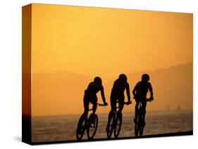 Silhouette of Three Men Riding on the Beach-Mitch Diamond-Stretched Canvas