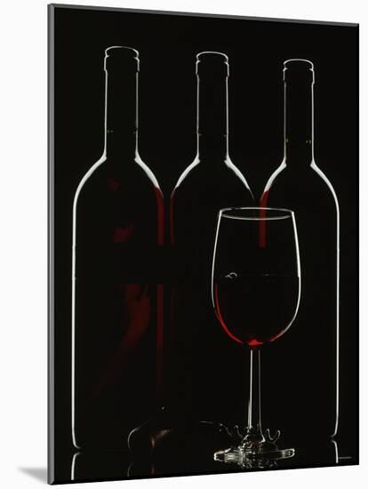 Silhouette of Three Red Wine Bottles and One Red Wine Glass-Walter Cimbal-Mounted Photographic Print