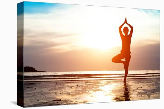 Silhouette Young Woman Practicing Yoga on the Beach at Sunset-De Visu-Stretched Canvas