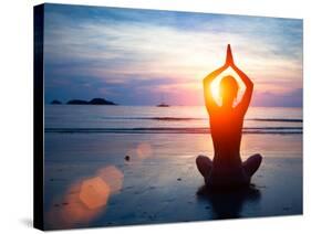 Silhouette Young Woman Practicing Yoga on the Beach at Sunset.-De Visu-Stretched Canvas