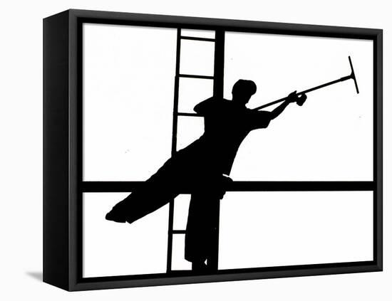 Silhouetted against the Bright Morning Sun, a Window Cleaner Stretches to Clean a Spot-null-Framed Stretched Canvas