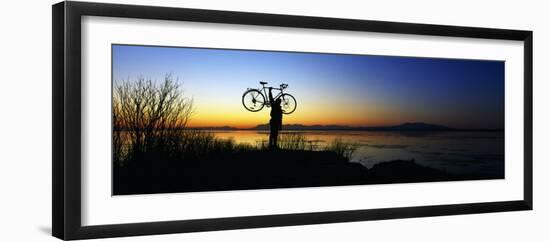 Silhouetted Cyclist Holding Bicycle over Head, River's Edge, Sunset, Alaska-null-Framed Premium Photographic Print