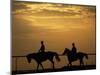 Silhouetted Men Riding on Horses, Dubai, UAE-Henry Horenstein-Mounted Photographic Print