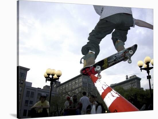 Skateboarder in Midair Knocking Over a Cone-null-Stretched Canvas