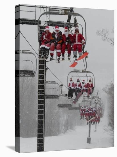 Skiers and Snowboarders Dressed as Santa Claus Ride up the Ski Lift-null-Stretched Canvas