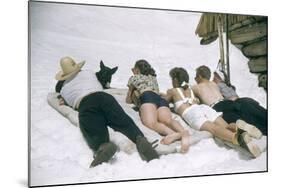 Skiers Sunbathing in Summer Fashions with Dog at Sun Valley Ski Resort, Idaho, April 22, 1947-George Silk-Mounted Photographic Print