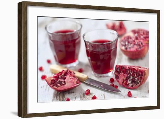 Sliced Pomegranates, Cores and Glasses with Pomegranate Juice-Jana Ihle-Framed Photographic Print