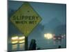 Slippery When Wet Sign in Fore with Traffic in Background in Rain on California Highway 14-Ralph Crane-Mounted Photographic Print