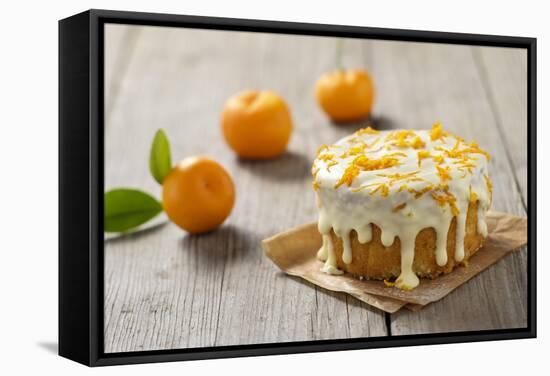 Small Orange Cake with White Icing on Wooden Table-Jana Ihle-Framed Stretched Canvas