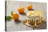 Small Orange Cake with White Icing on Wooden Table-Jana Ihle-Stretched Canvas