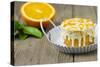 Small Orange Cake with White Icing on Wooden Table-Jana Ihle-Stretched Canvas