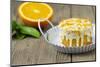 Small Orange Cake with White Icing on Wooden Table-Jana Ihle-Mounted Photographic Print